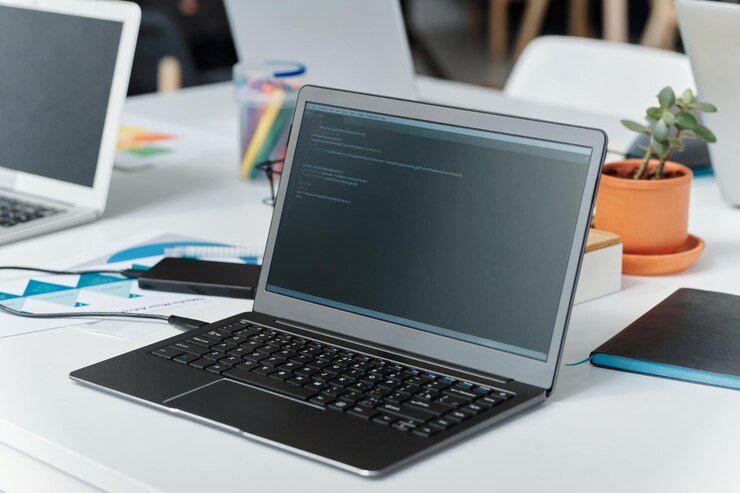 Foto laptop con códigos en el monitor de la oficina