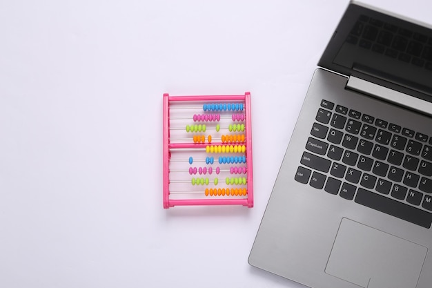 Foto laptop com ábaco de brinquedo no fundo branco conceito de educação