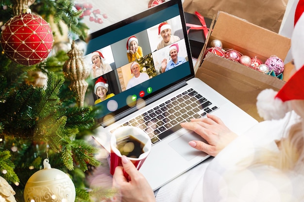 Laptop com caixa de presente e fundo de luzes de natal.