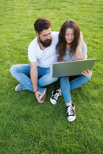 Laptop com conexão à internet Homem barbudo e garota sexy usam laptop ao ar livre Computador portátil Notebook e pc Tecnologia de laptop Acesso online Navegação na Internet Vida moderna Redes sociais