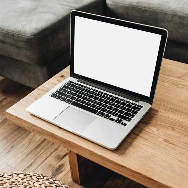 Laptop com tela de maquete em branco na mesa de madeira sólida.