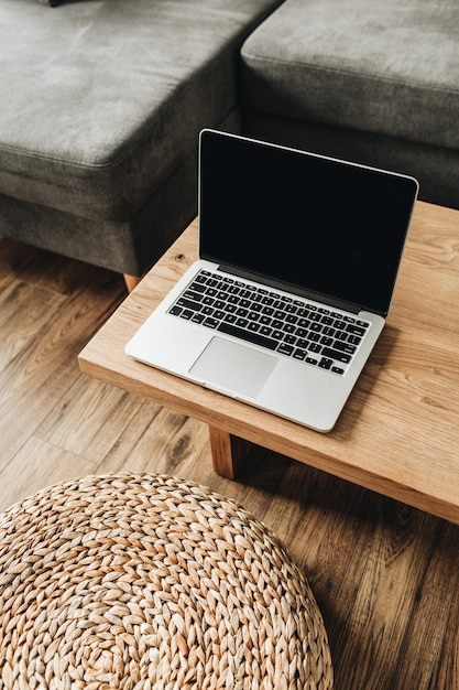 Laptop com tela de maquete em branco na mesa de madeira sólida.