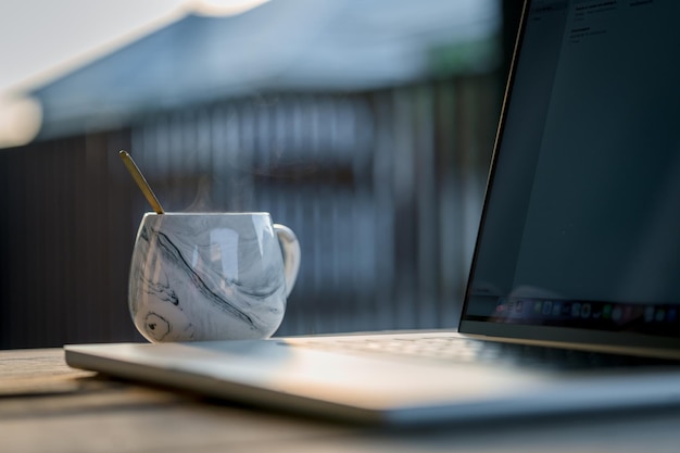 Laptop com tela preta em branco em uma mesa de madeira