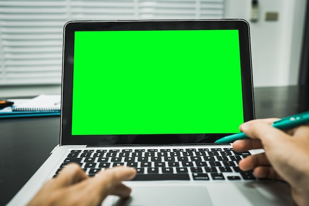 Foto laptop com tela verde no negócio de escritório