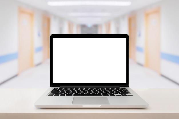 Laptop-Computer auf medizinischem Tisch mit Krankenhaushintergrund