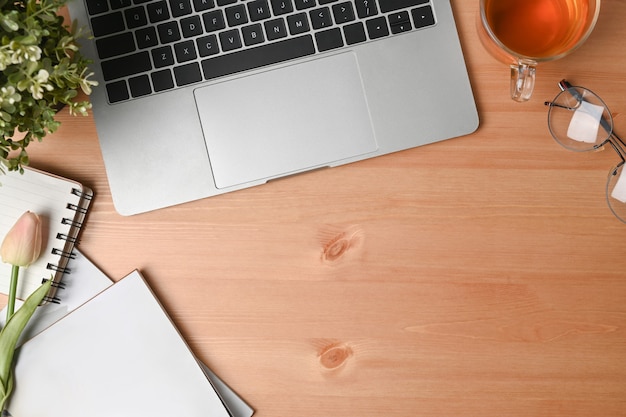 Laptop-Computer, Notebook, Tasse und Gläser auf dem Schreibtisch aus Holz.