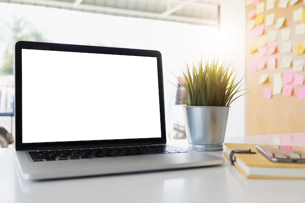 Foto laptop-computer und plakatarbeitsplatzhintergrund des leeren bildschirms im modernen büro