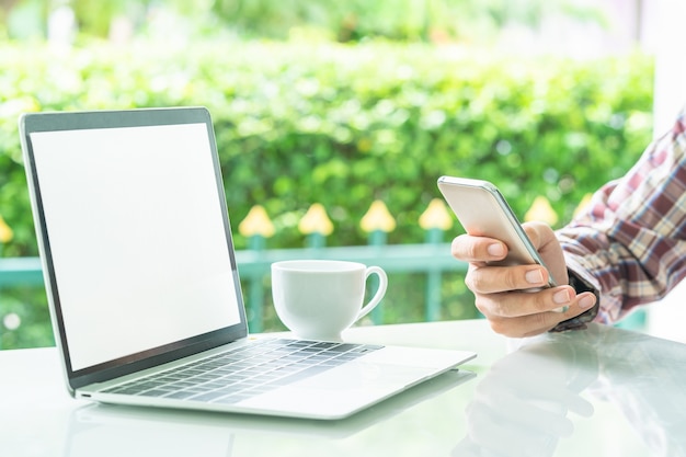 Laptop-Computer und Tasse Kaffee auf der Tabelle im Freien