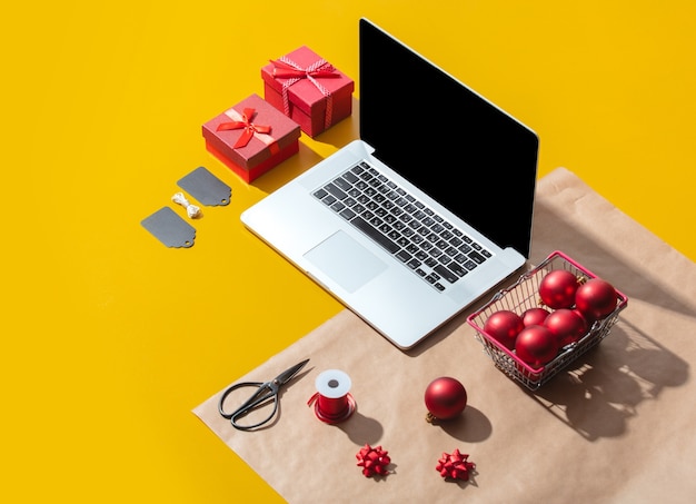 Laptop-Computer und Weihnachtsgeschenke und Gegenstände zum Verpacken