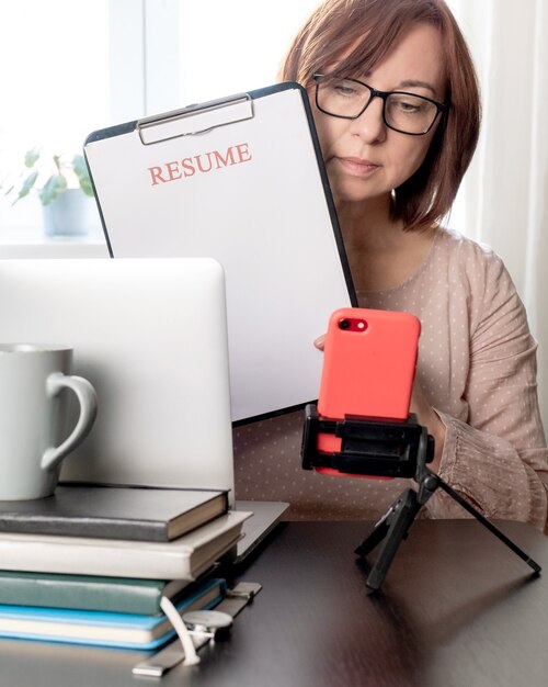 Laptop currículum con mujer de mediana edad 50 más aplicación de hoja de cv en blanco de lugar de trabajo