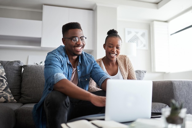 Laptop de casal negro e planejamento de contas de orçamento financeiro e empréstimo com conexão de rede ou wi-fi doméstico no sofá da sala Homem e mulher no site bancário de mídia social ou fazendo compras on-line