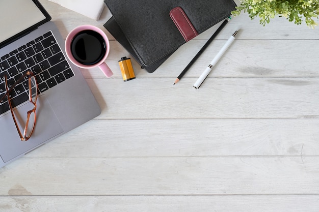 Laptop de mesa de escritório com café, notebook e material de escritório