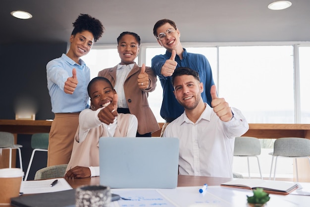 Foto laptop de pessoas de negócios e reunião com polegares para cima para sucesso bom trabalho ou planejamento de trabalho em equipe no escritório grupo de funcionários criativos por computador mostrando polegar emoji sim sinal ou como para inicialização