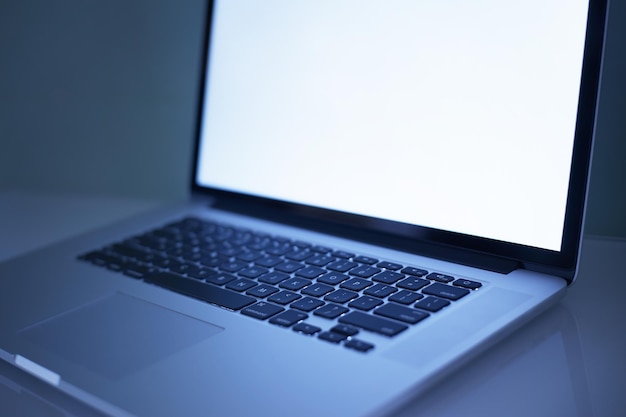 Foto laptop de tela brilhante e em branco para foco seletivo de propósito de design com aplicação de filtro azul