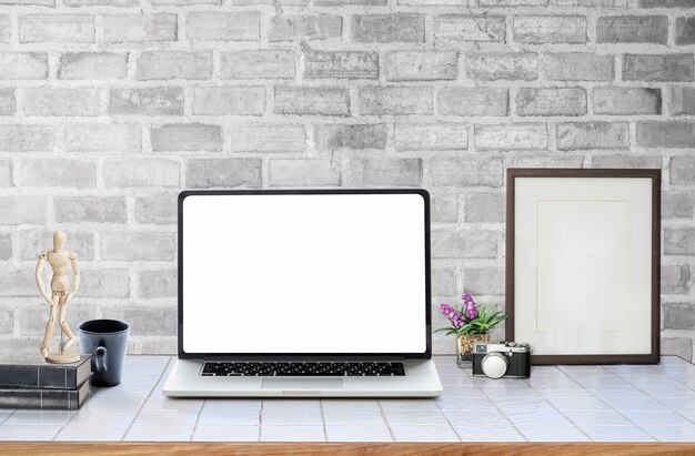 Laptop de tela em branco de maquete com suprimentos na mesa branca.