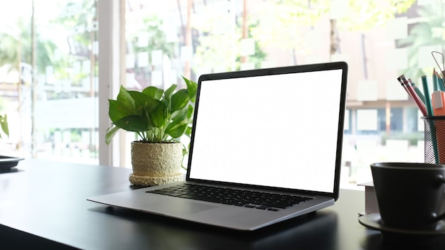 Laptop de tela em branco de maquete na mesa preta e material de escritório. para montagem de exposição do produto.