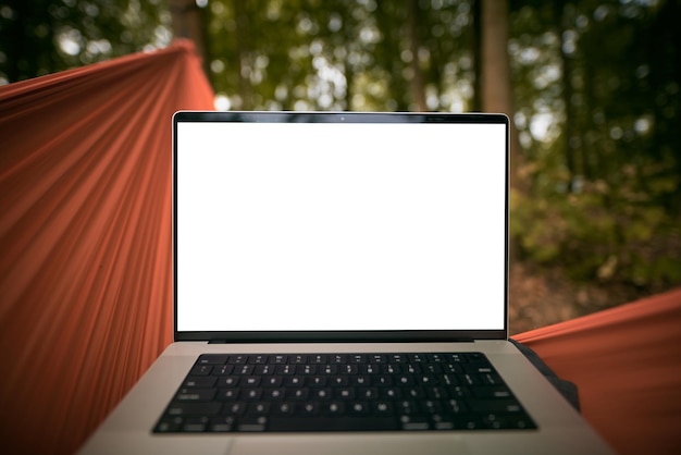 Laptop de um nômade digital remoto em uma rede com a primeira perspectiva de fundo de floresta verde trabalhando em um laptop moderno enquanto está na natureza
