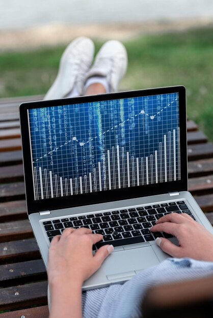 Foto laptop descansando en el regazo de una mujer con la pierna cruzada al aire libre realizando su trabajo remoto minicomputadora colocada en la superficie superior parte de las piernas afuera haciendo trabajos informáticos