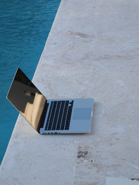 Laptop durch Schwimmbad.