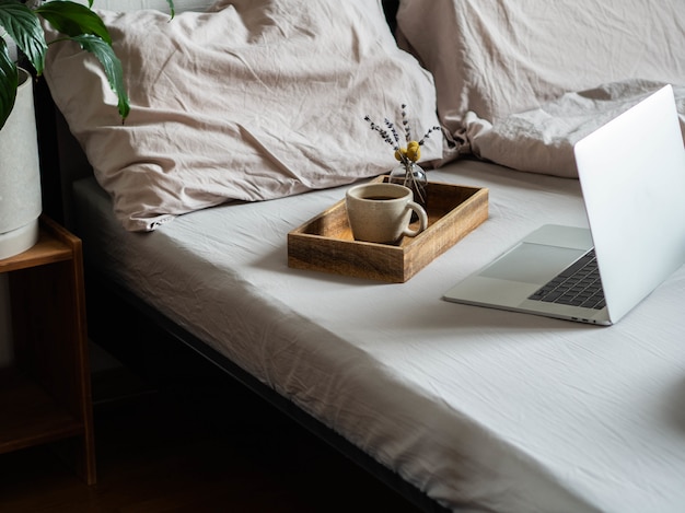 Laptop e café na cama no quarto