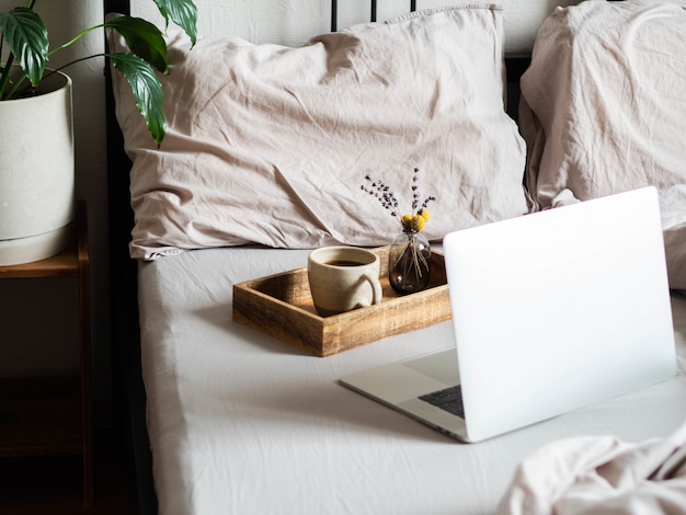 Laptop e café na cama no quarto