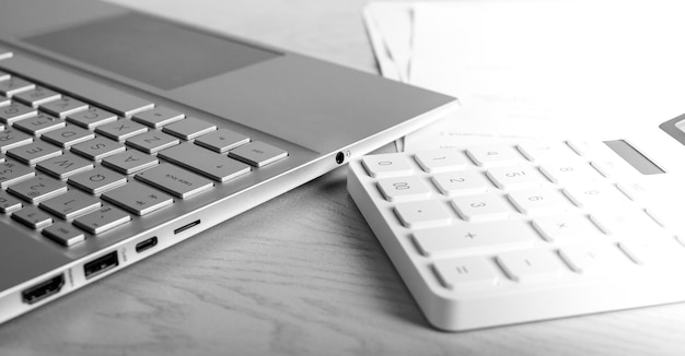 Laptop e calculadora na mesa Trabalho de contador no local de trabalho Preparação de relatório analítico de dados estatísticos