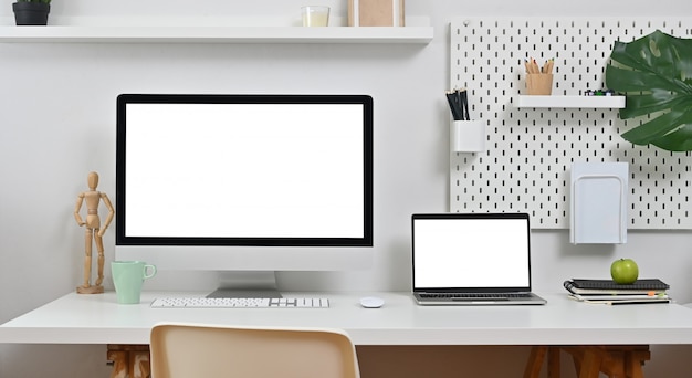 Laptop e computador na mesa de escritório de espaço de trabalho.