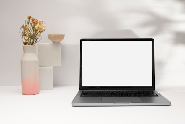 Foto laptop e flores em arranjo de vaso