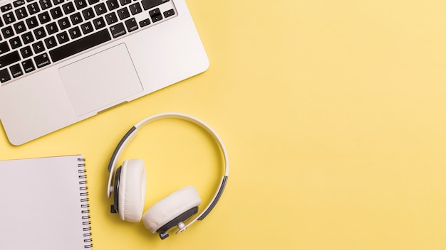 Foto laptop e fones de ouvido no fundo amarelo