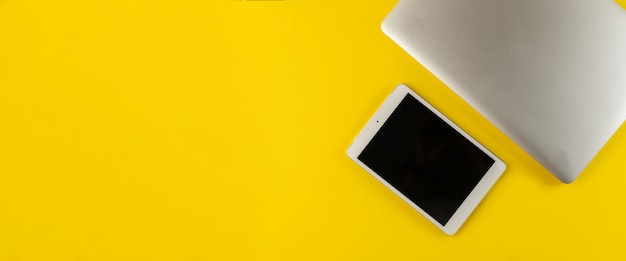 Laptop e tablet isolados em amarelo