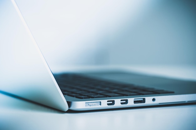 Laptop elegante y moderno que muestra opciones de conectividad y diseño elegante en un entorno minimalista
