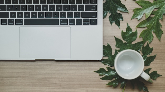 Laptop em uma mesa de madeira e uma xícara de café