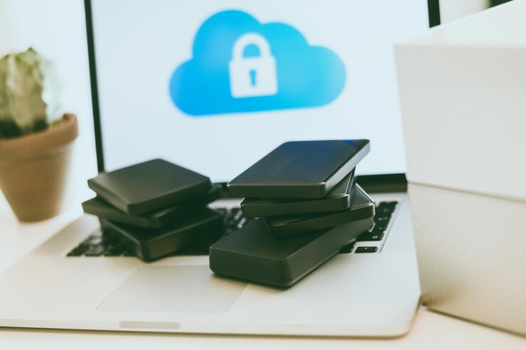 Foto laptop en el escritorio con computadora de almacenamiento conectada a la red nas y pila de discos duros tecnología en la nube