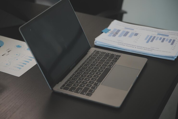 Foto laptop en un escritorio en una oficina financiera abierta