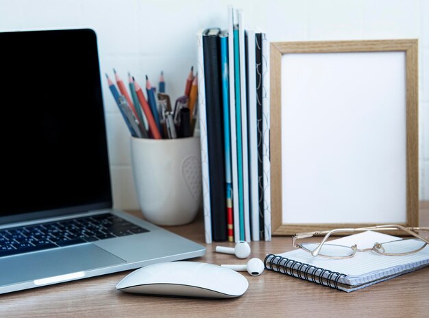 Foto laptop de escritorio con suministros de oficina en la mesa