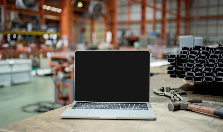 Laptop con fondo negro vacío en la fábrica. Trabajador y fabricación con concepto de tecnología informática.