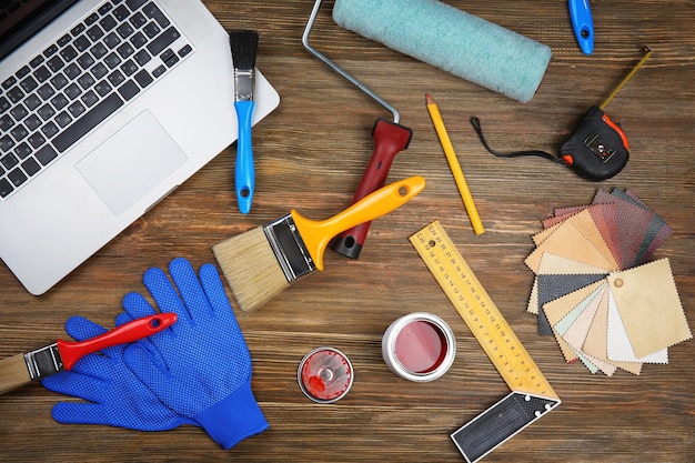 Foto laptop y herramientas de pintura en mesa de madera