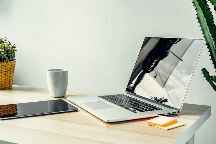 Foto laptop in einem hellen raum auf arbeitstisch mit bürozubehör