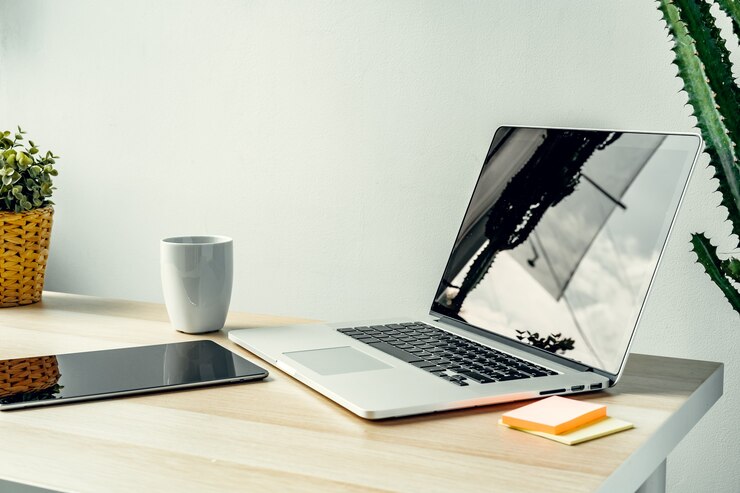 Foto laptop in einem hellen raum auf einem arbeitstisch mit büromaterial