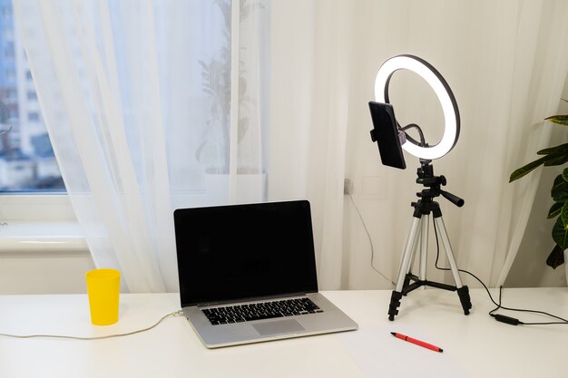 Laptop, Lampe und Stativ auf dem Tisch zum Online-Interview