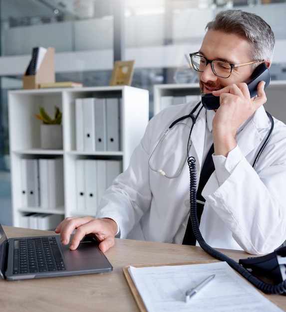 Laptop-Mann und Arzt am Telefon sprechen oder chatten, um sich für eine Beratung im Krankenhaus zu melden Telemedizin-Telefon und reife männliche medizinische Fachgespräche oder Diskussionen