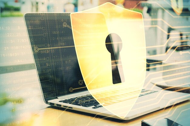 Laptop en la mesa con el holograma del escudo antivirus
