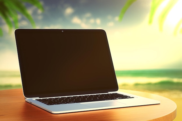 Laptop en una mesa de madera en la playa al atardecer