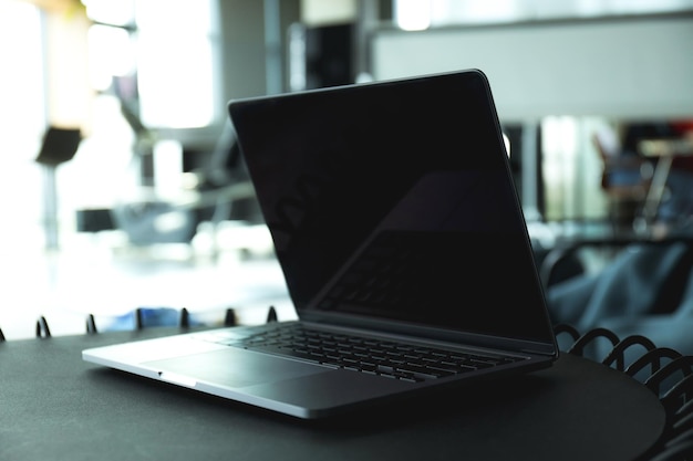 Laptop en una mesa negra en un espacio de trabajo en primer plano