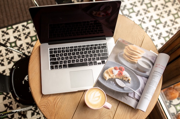 Laptop mit einer Tasse Kaffee. Von zuhause aus arbeiten. Arbeit in einem Café. Zeit für dich