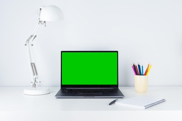 Laptop mit Greenscreen-Tischlampe und Stiften auf dem Desktop