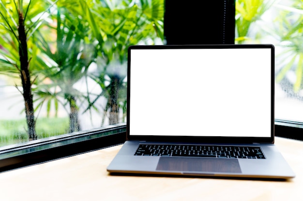 Laptop mit leerem Bildschirm auf dem Schreibtisch, im Büro, leerer Raum. Konzept der Arbeit mit Laptop und Online-Online-Kommunikation
