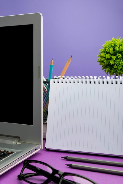 Laptop mit wichtigen Informationen auf dem Tisch mit Pflanze und Tasse Kaffee Entscheidende Ankündigungen auf dem Computerbildschirm auf dem Schreibtisch mit Blume und Becher