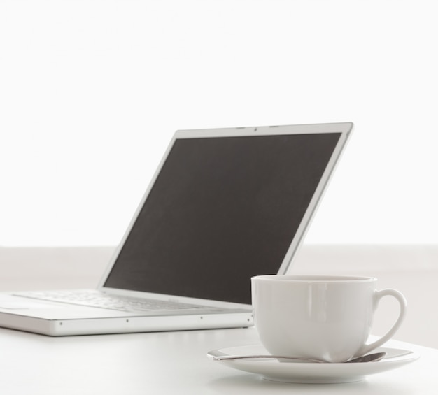 Laptop moderno e xícara de chá em uma mesa