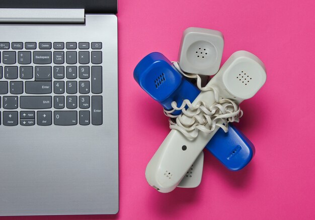 Laptop y muchos teléfonos con cable envuelto en rosa